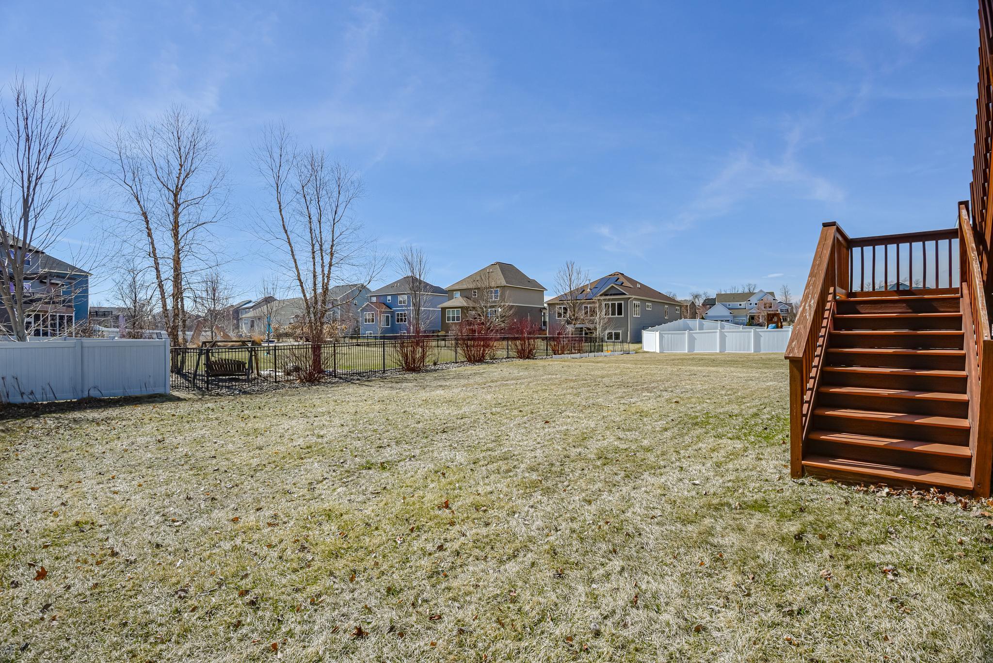 Deck steps lead to the large backyard
