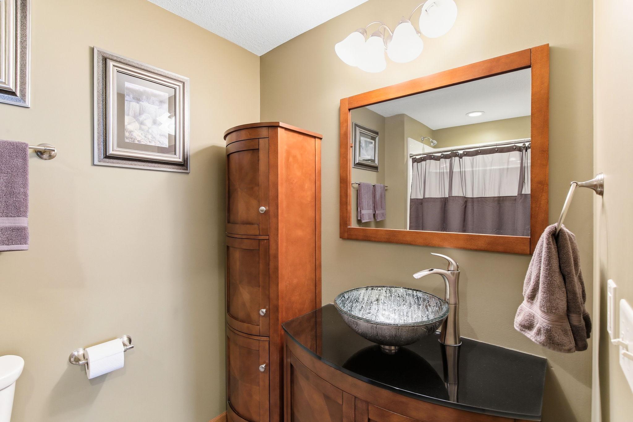 Lower Level Full bath. There are stairs from the garage that lead to a hall by this bathroom and the laundry. Great access for when working outside.