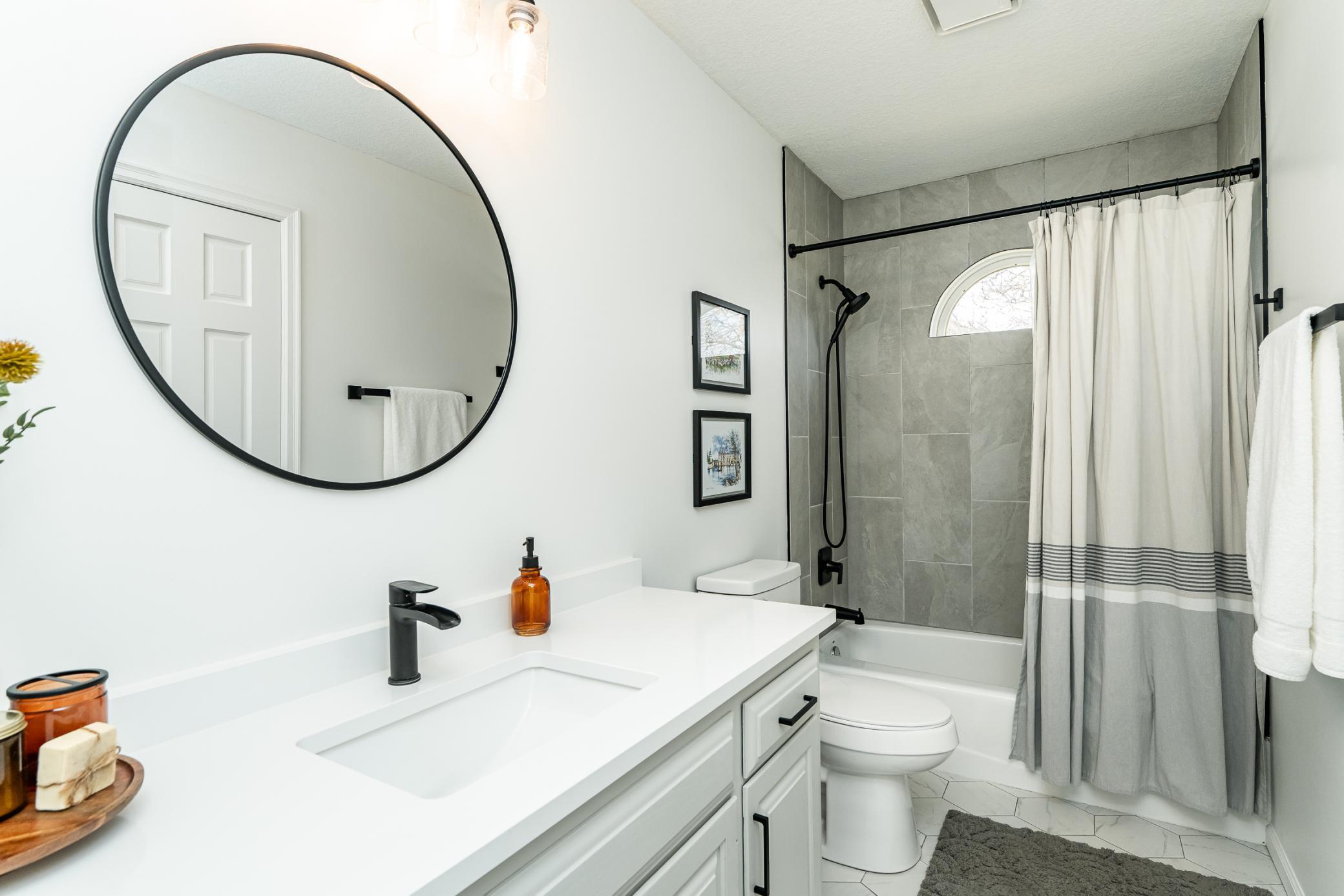 Main floor full bath with quartz countertops and tiled shower. There is also a linen closet! (just not pictured).