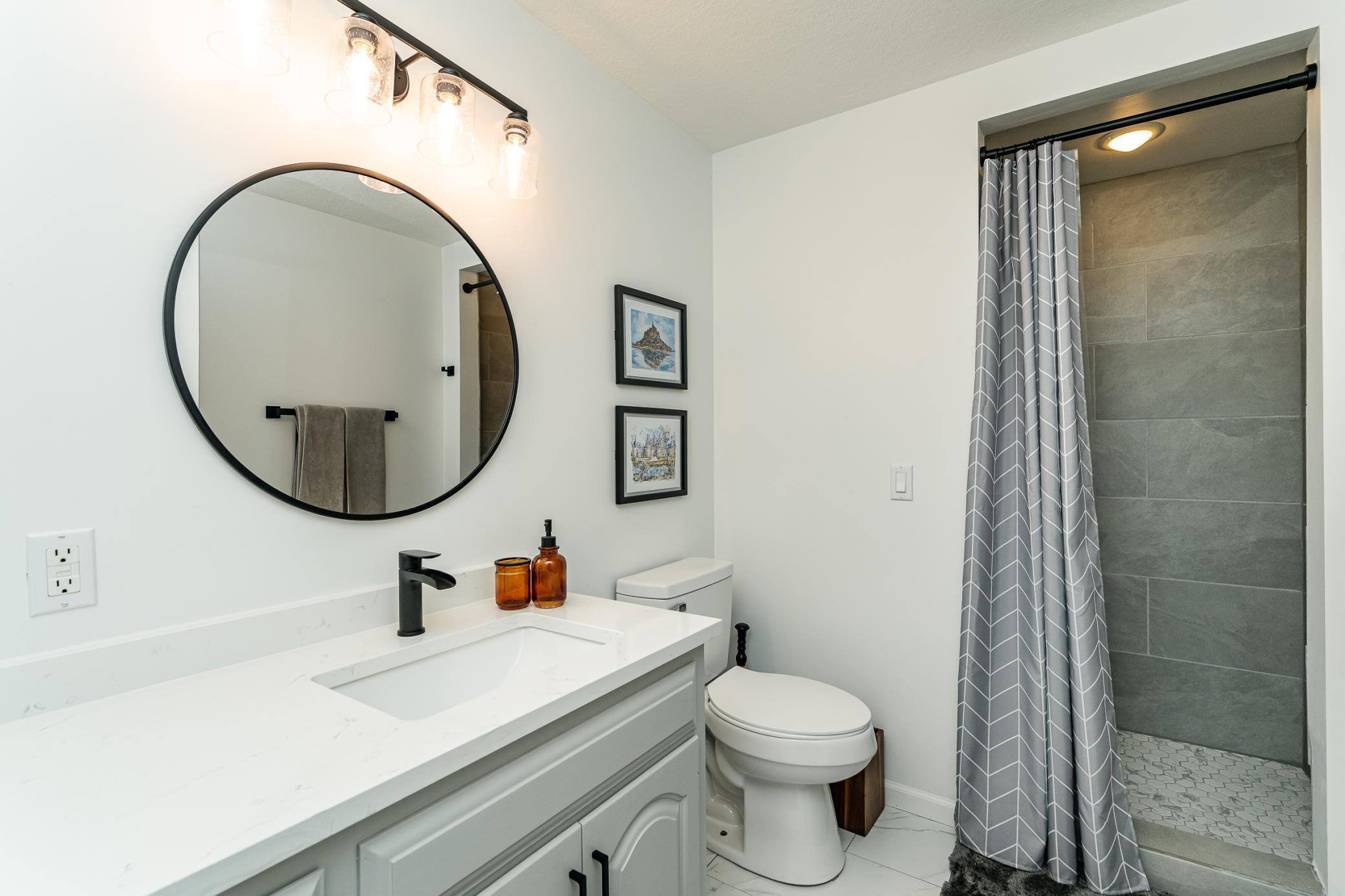 Lower level 3/4 bath with quartz counters and tiled shower and floors.
