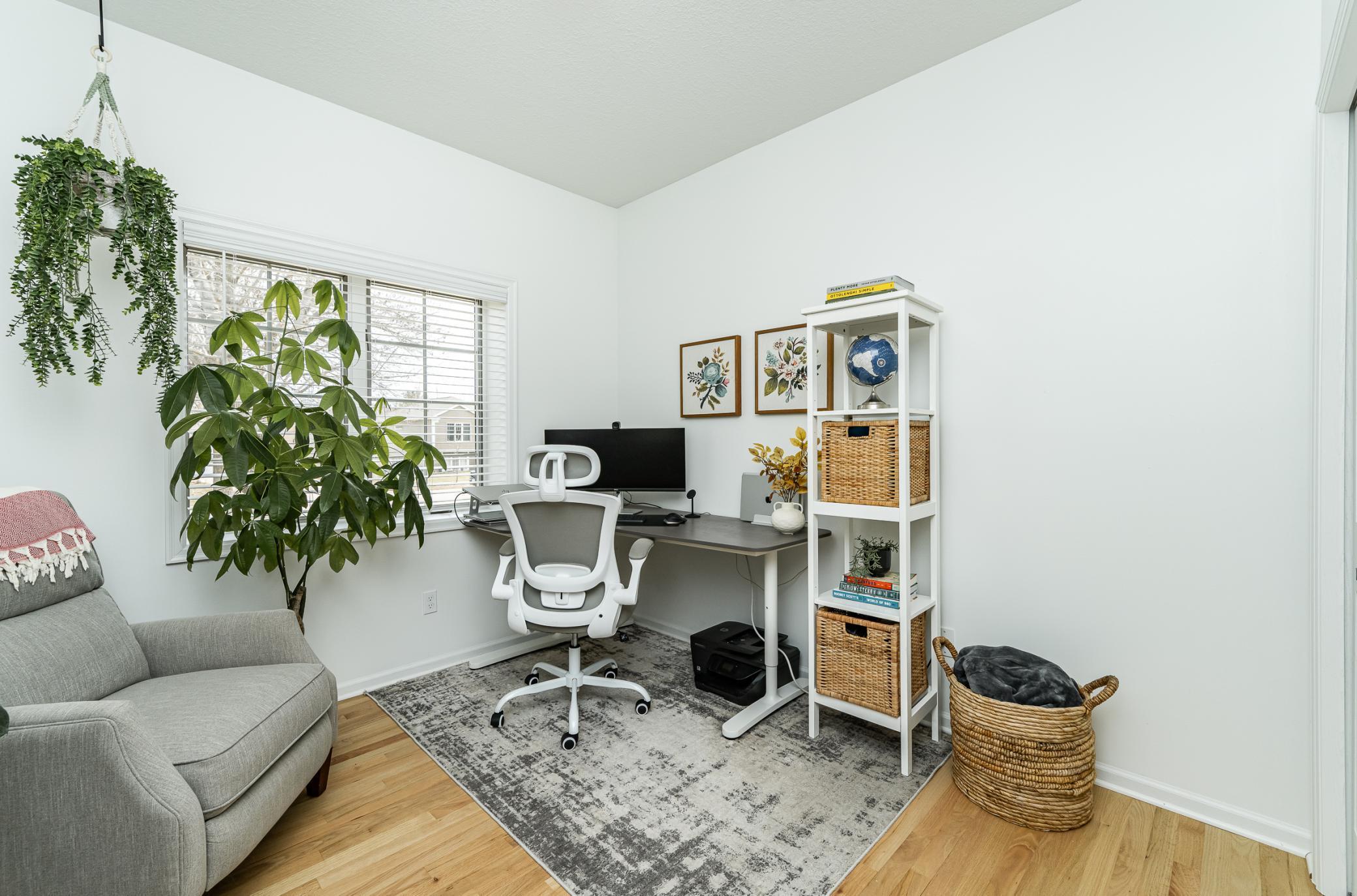 Bedroom three on main features hardwood floors and wood blinds.