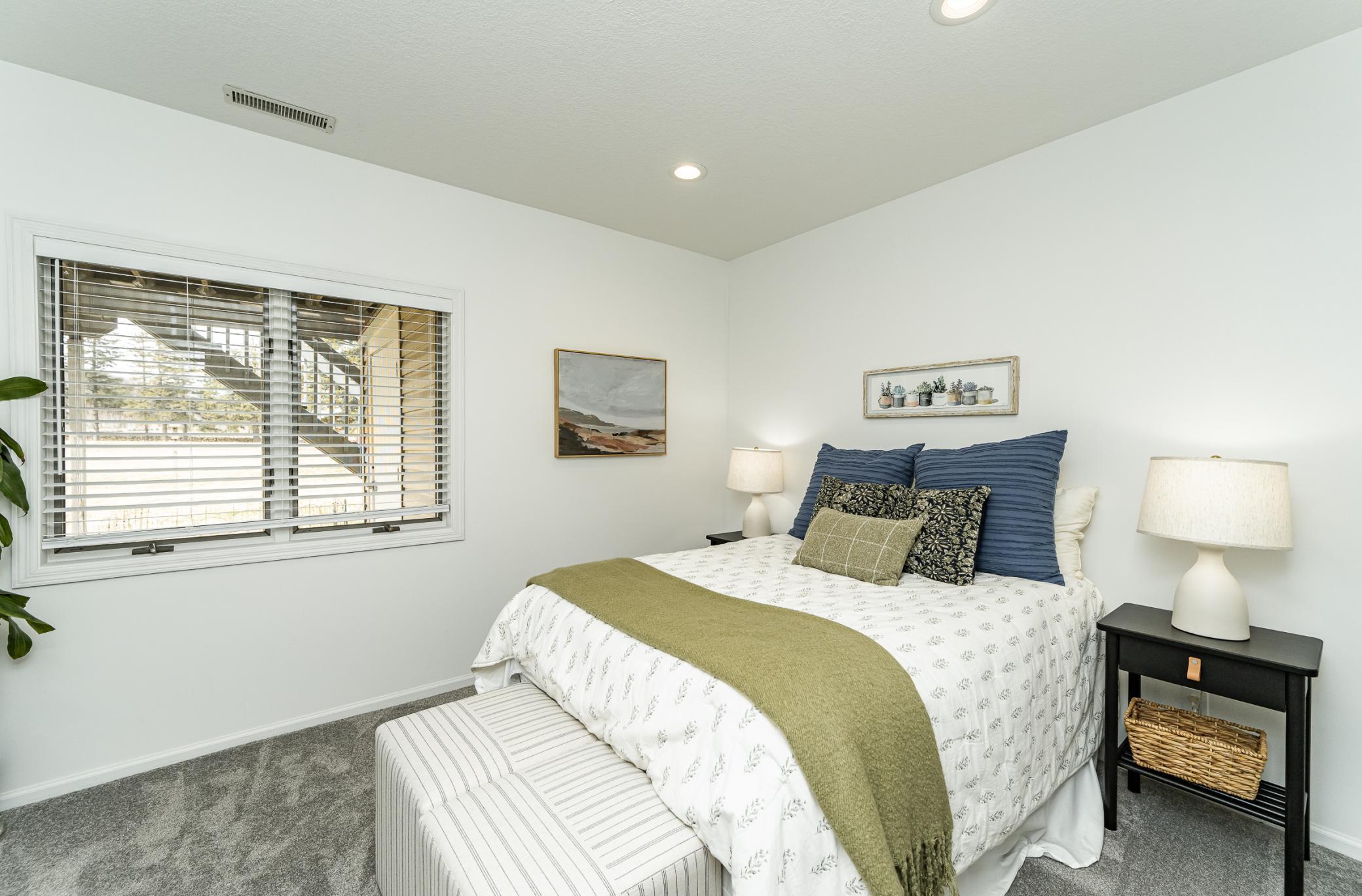 Bedroom four with wood blinds faces private backyard.