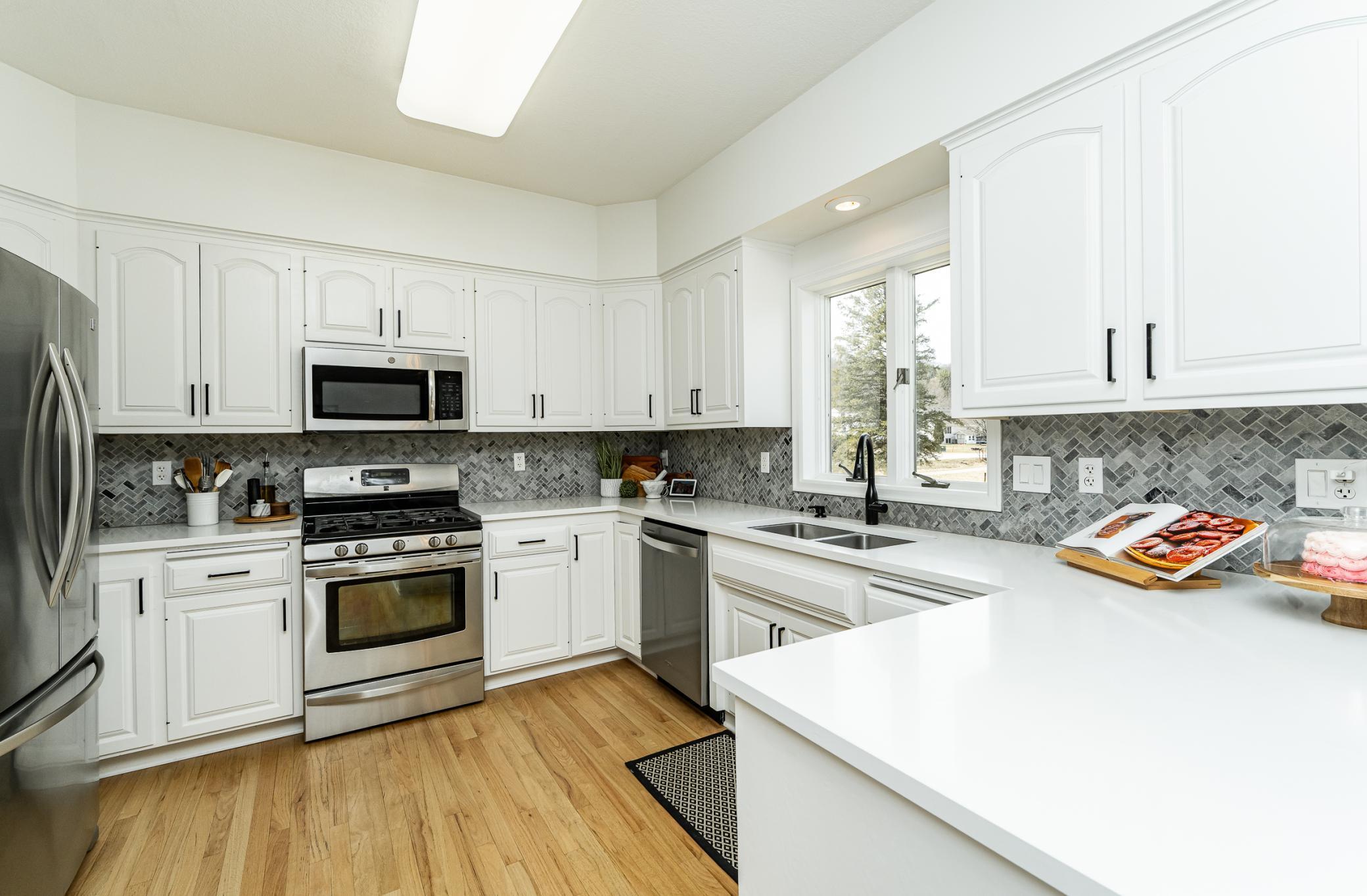 Quartz countertops, beautiful tiled backsplash, gas stove and new dishwasher.