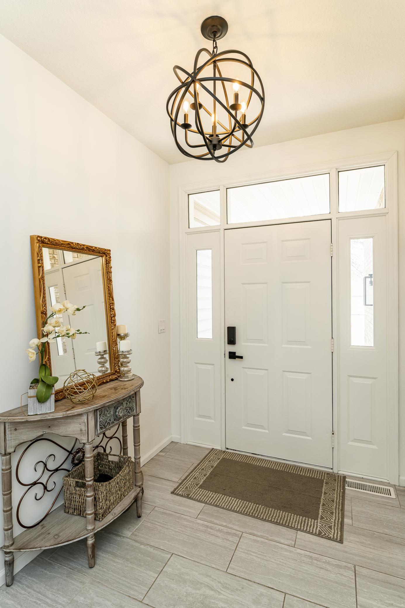 Bright and welcoming foyer with transom window and tiled floor.