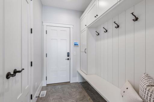 Spacious mudroom featuring smart storage solutions and access to the attached three-car garage.