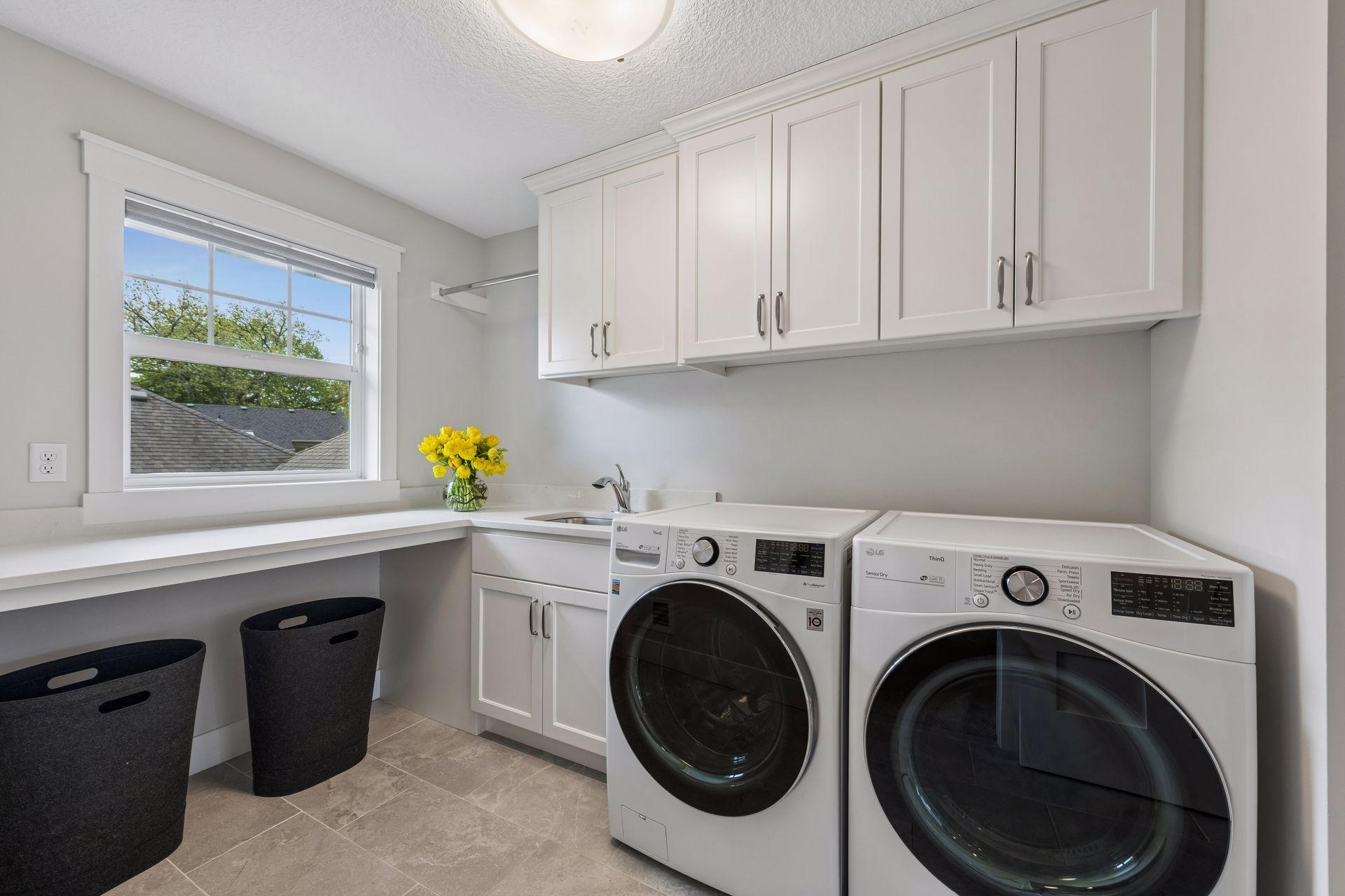 Convenient second-floor laundry room with sink and storage just off the primary closet