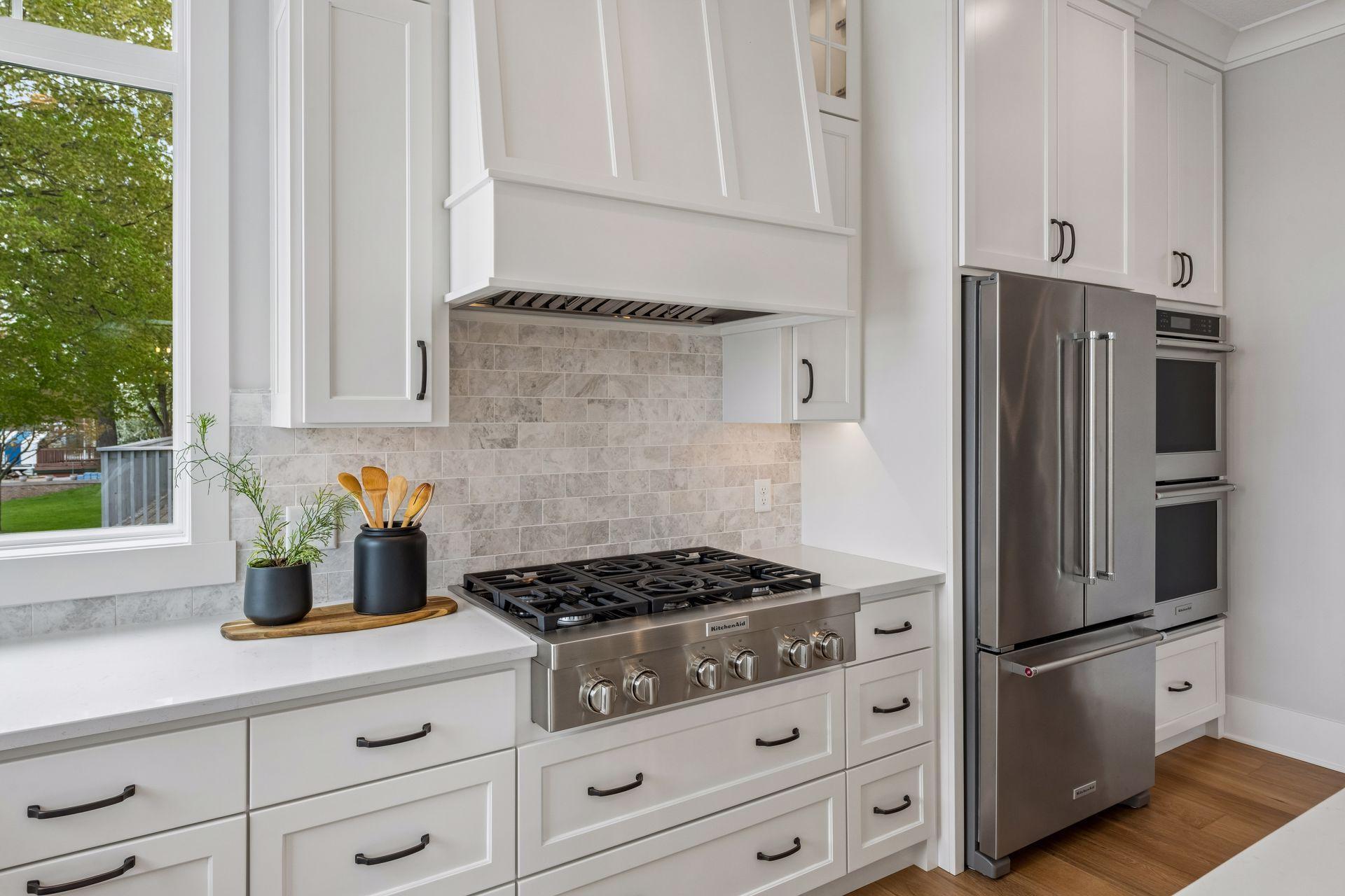 Professional-series KitchenAid suite anchors the kitchen, featuring a high-performance stove, double ovens, and a stainless steel refrigerator.