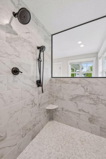 Indulge in the oversized walk-in shower, featuring a luxurious array of shower heads and a sleek, open design.