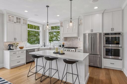 The chefâs kitchen shines with an oversized quartz island, marble backsplash, and premium appliances.