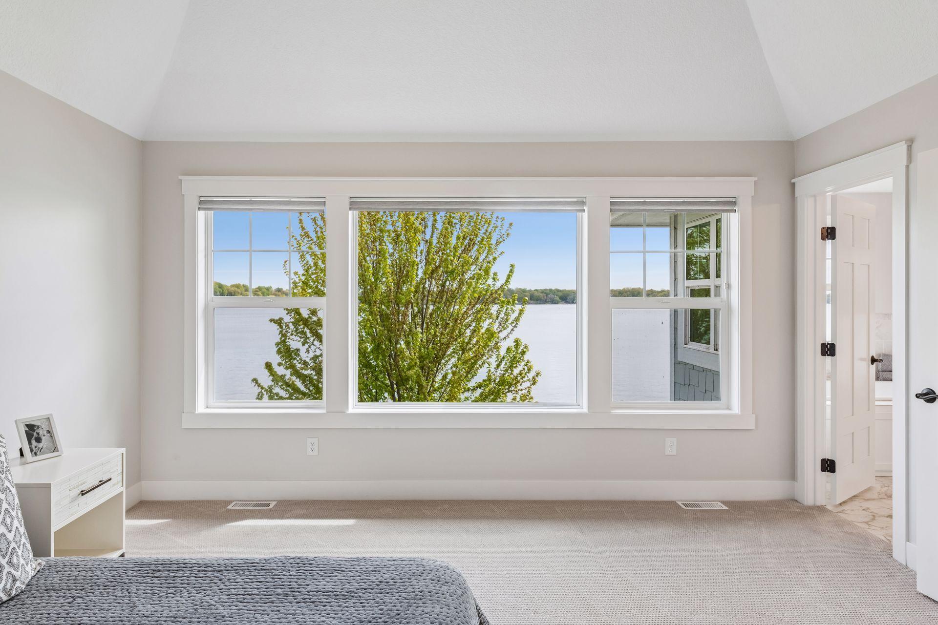 Walls of glass in the primary retreat offer an ever-changing lakeside vista and a serene start to every morning