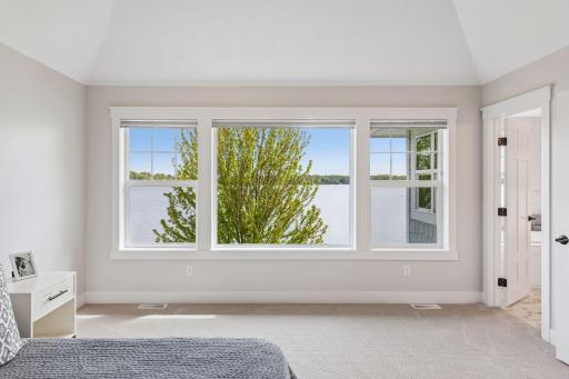 Walls of glass in the primary retreat offer an ever-changing lakeside vista and a serene start to every morning.