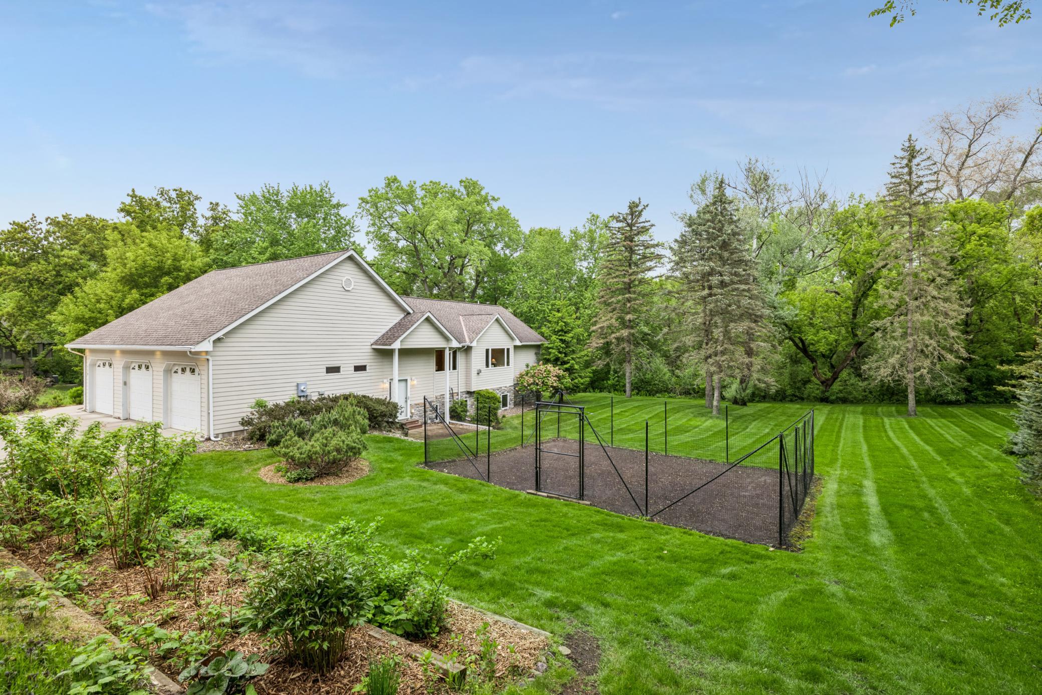 Mature trees, expansive lawn space, & a large fenced garden.