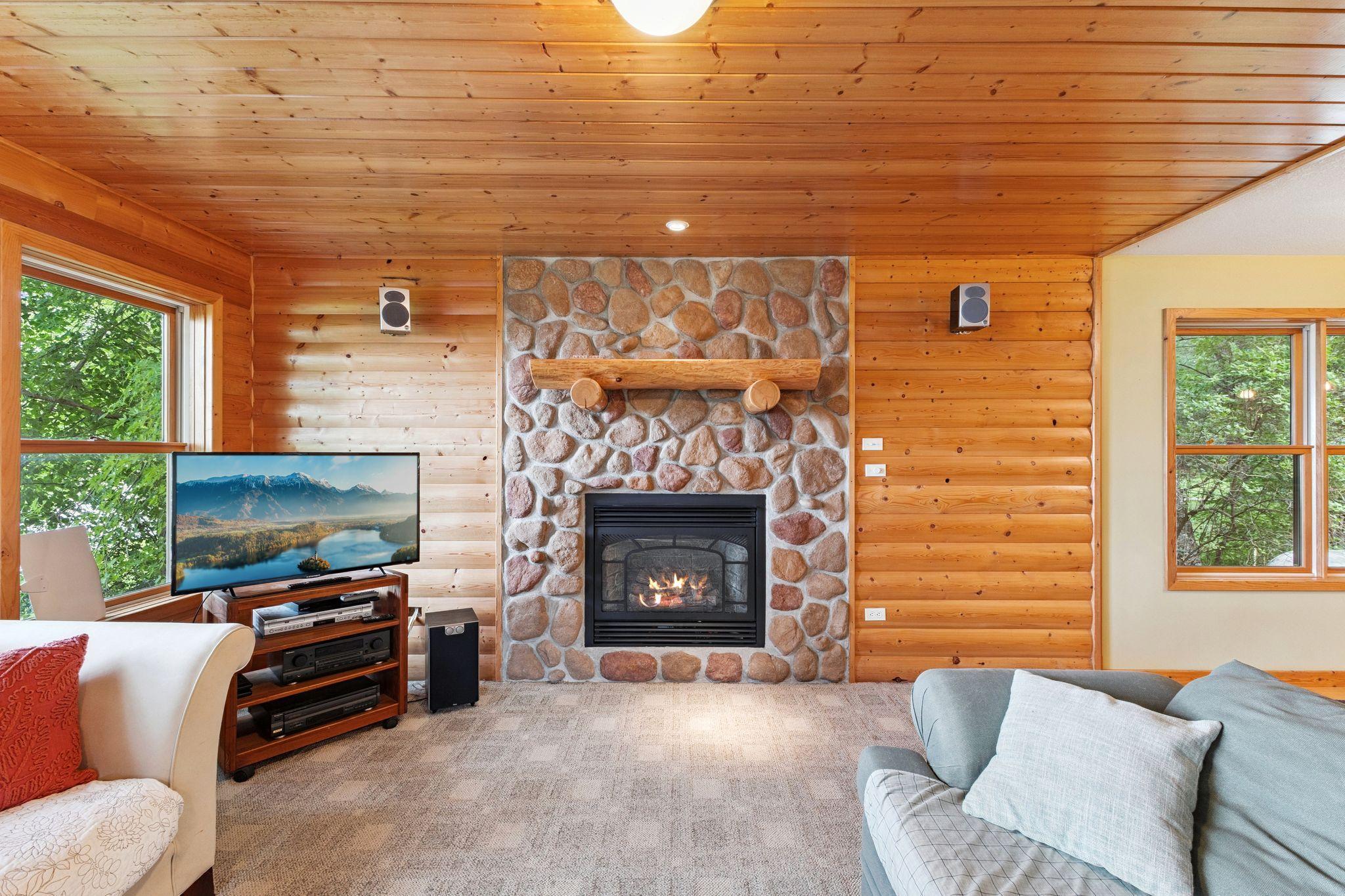 Gorgeous stone gas fireplace is the focal point here in the living room