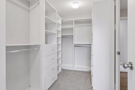 Primary walk in closet opens to upper level laundry room