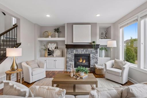 Living room features custom fireplace wall with built-ins