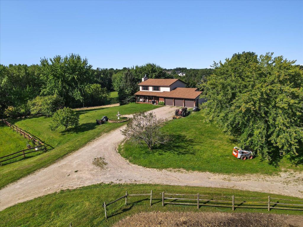 Long private driveway approach with scenic surroundings and a spacious multi-stall attached garage offering abundant storage and workspace potential.