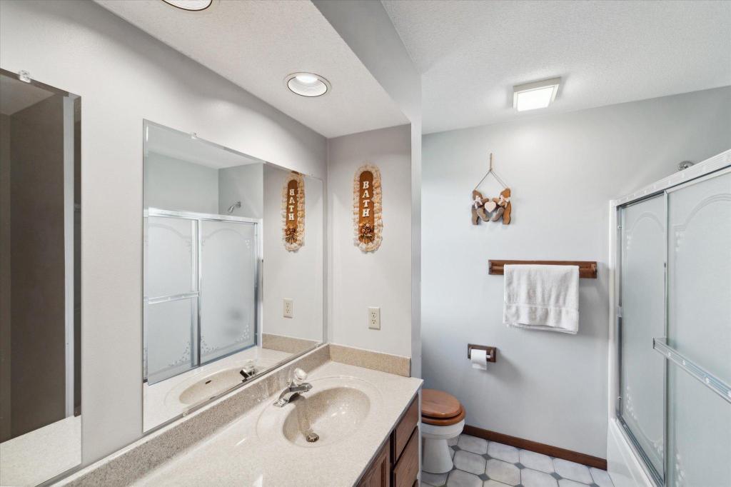 Spacious upper level guest bathroom featuring updated countertops, modern lighting, and walk-in shower.
