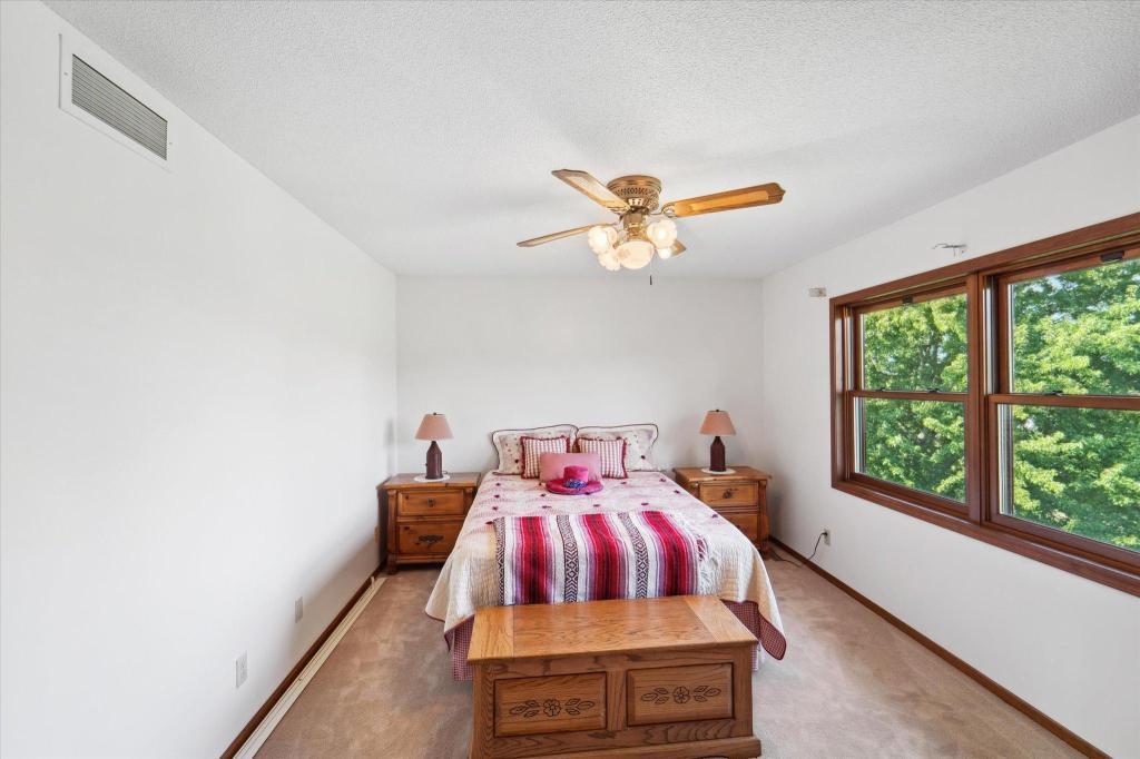 Bright upper-level bedroom with peaceful nature views and generous closet space.
