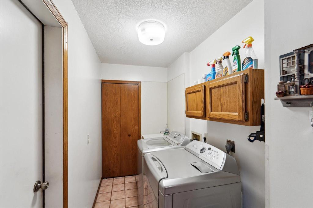 Convenient main-level laundry room with extra storage cabinetry and functional workspace.