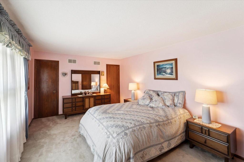 Spacious primary bedroom with soft natural light, neutral finishes, and plenty of room for additional furniture.
