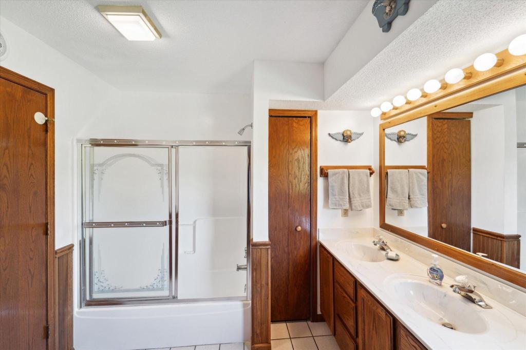 Main floor bathroom featuring dual sinks, extensive vanity space, and a walk-in shower.