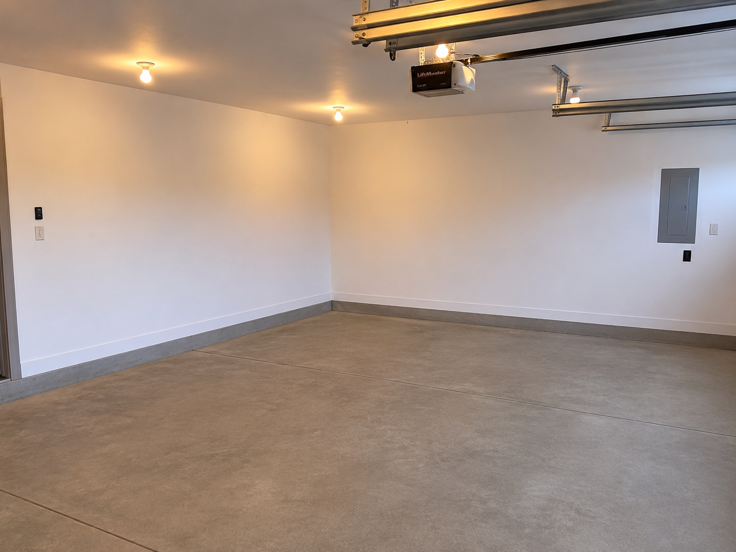 Finished and sheetrocked garage offering clean, versatile space for vehicles, storage, or workshop use.