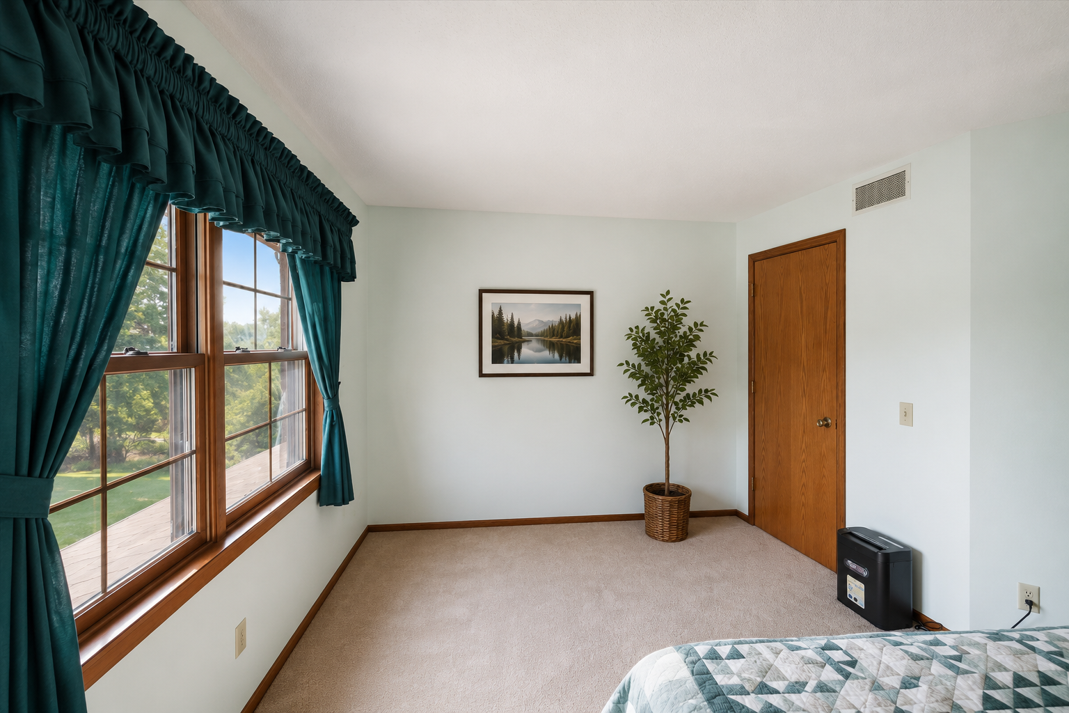 Spacious upper-level bedroom with large windows, abundant natural light, and peaceful countryside views.