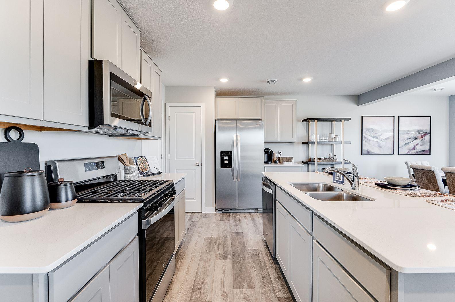 Gorgeous stone gray cabinets with quartz countertops, beautiful stainless appliances with vented microhood to the outside. (Model photo, colors may vary)