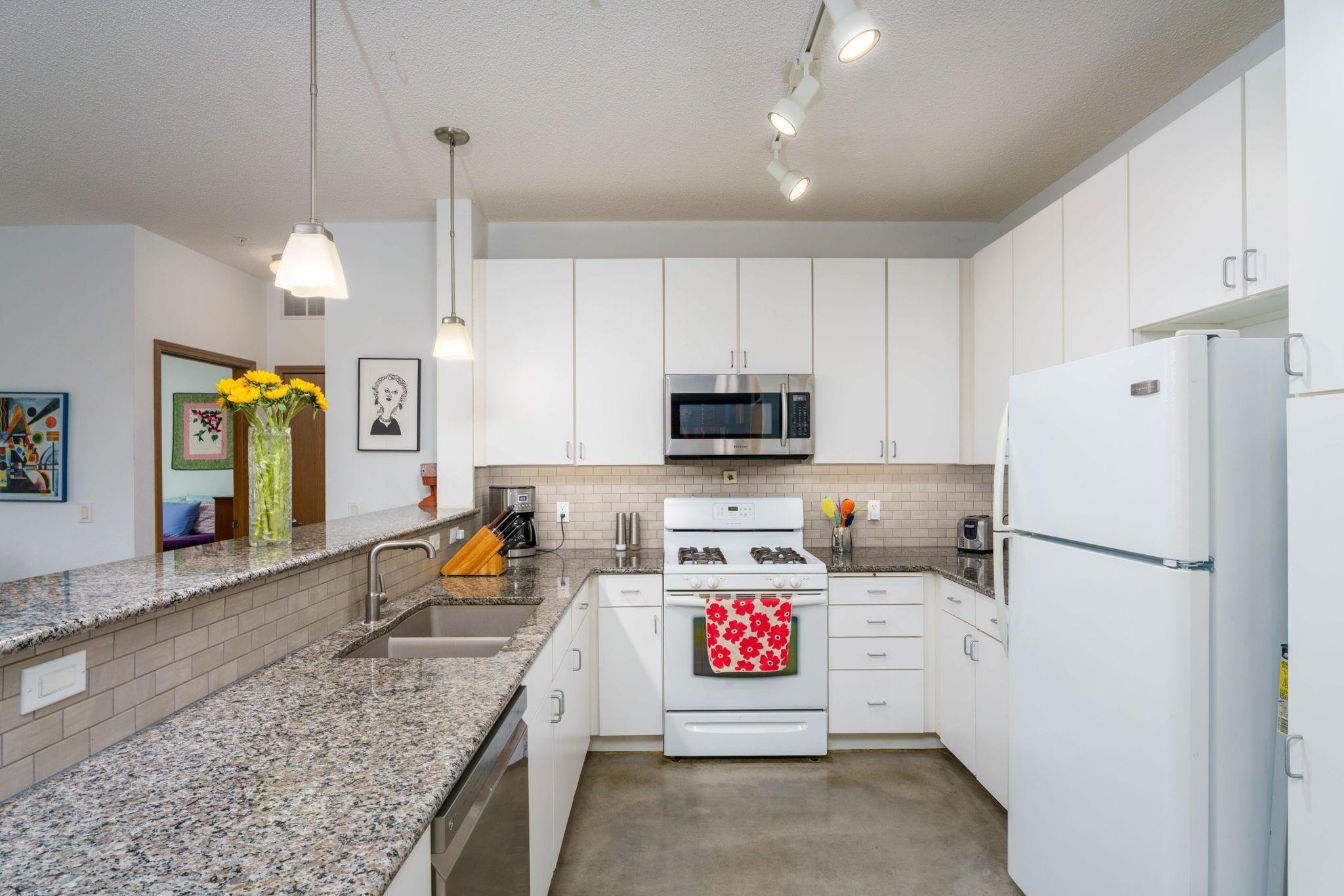 Kitchen with granite countertops. Light and bright.