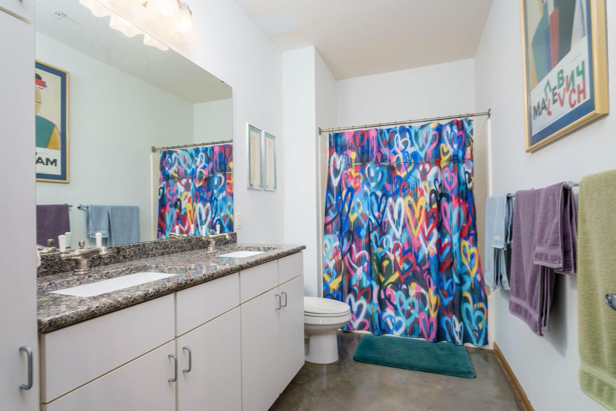 Bathroom, with two sinks, granite countertops and plenty of storage.