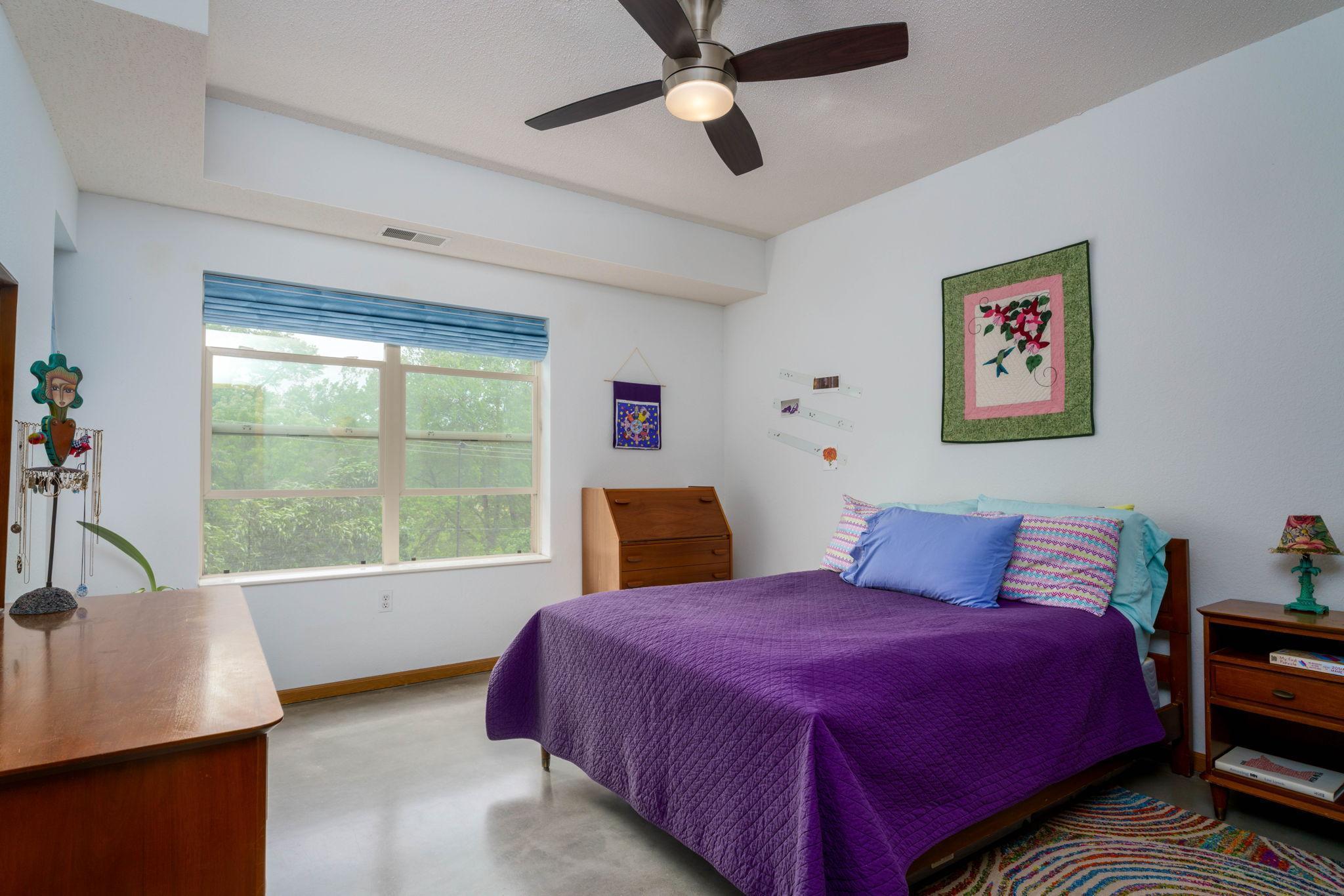 Primary bedroom with walk in closet and tree top west facing windows.