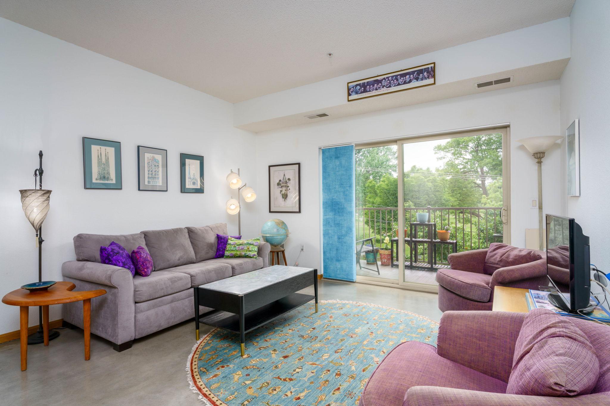 Living room with gleaming concrete floors- west facing for lots of afternoon/early evening light.