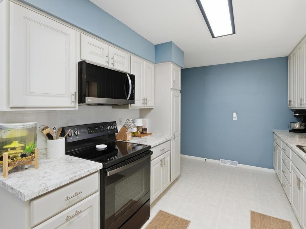 The kitchen highlights include durable laminate countertops, a smooth-top range, and an over-the-range microwave for space efficiency.