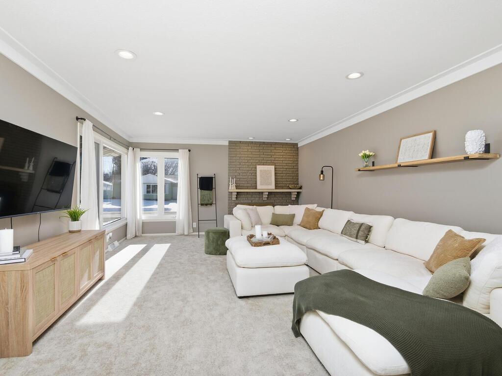 An expansive front window floods the main living area with natural light, perfect for relaxing or entertaining guests.