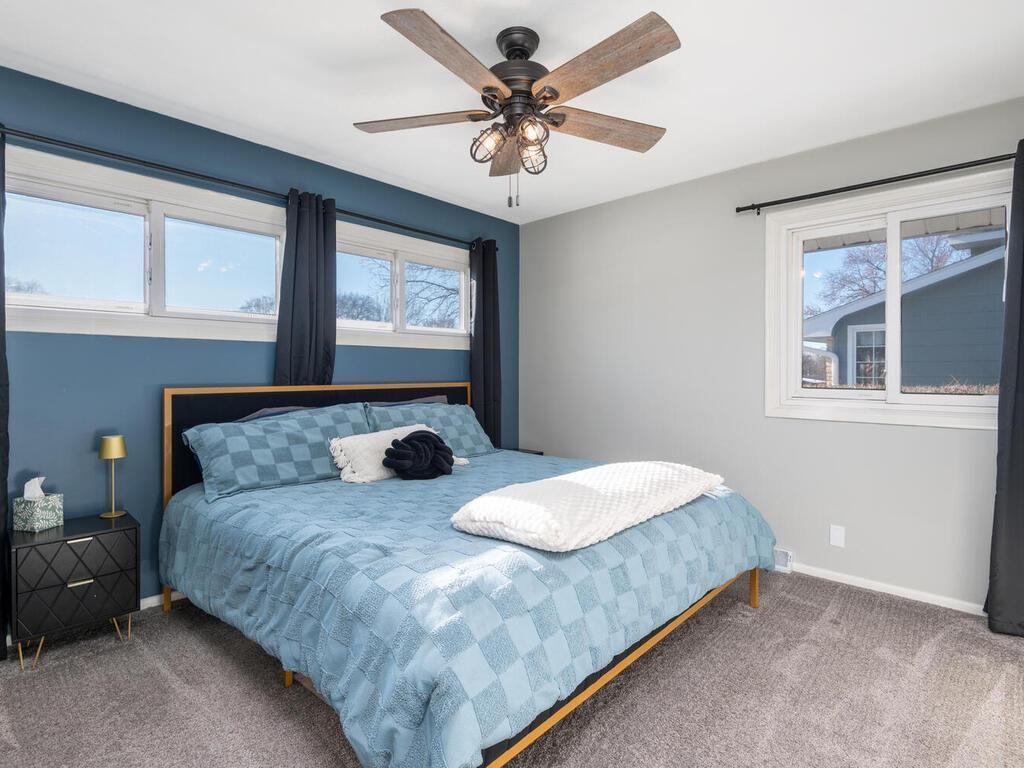 The primary bedroom features a striking blue accent wall, neutral paint, and new, updated carpeting for comfort.