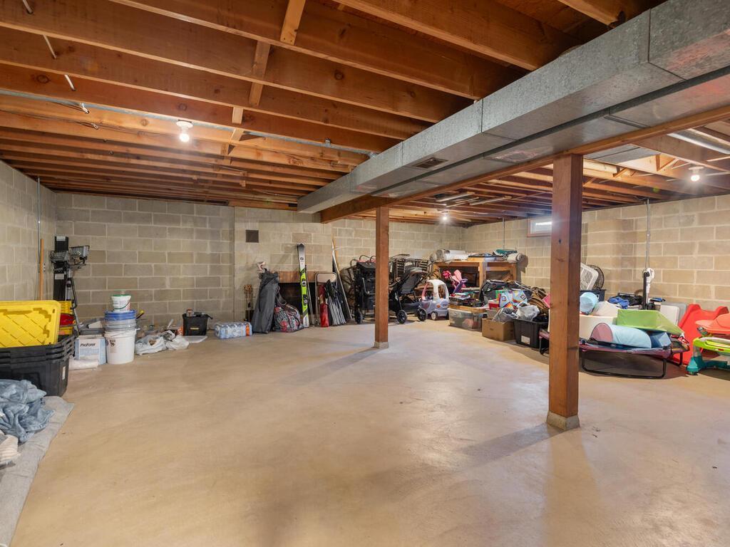 The massive unfinished lower level is a clean slate, perfect for a workshop, gym, or future finished living space.