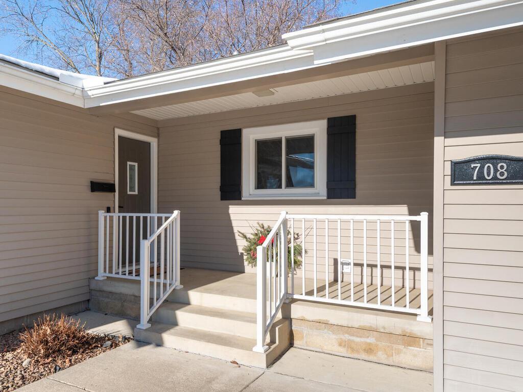 A welcoming front porch with updated white railings leads to a refreshed interior filled with modern touches.