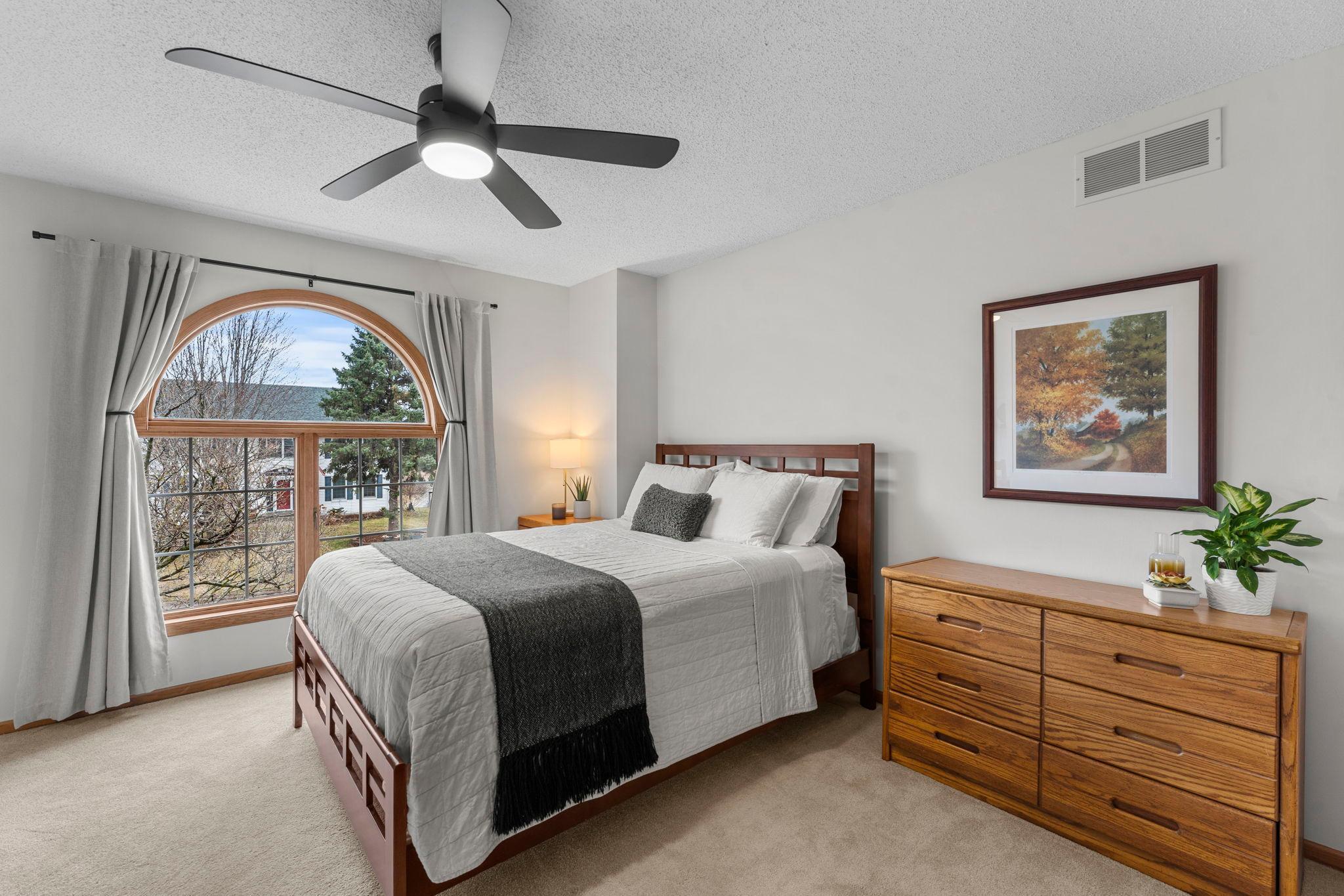 Bedroom two offers a large picture window, ceiling fan, generous closet space, and a charming nook ideal for a workspace.