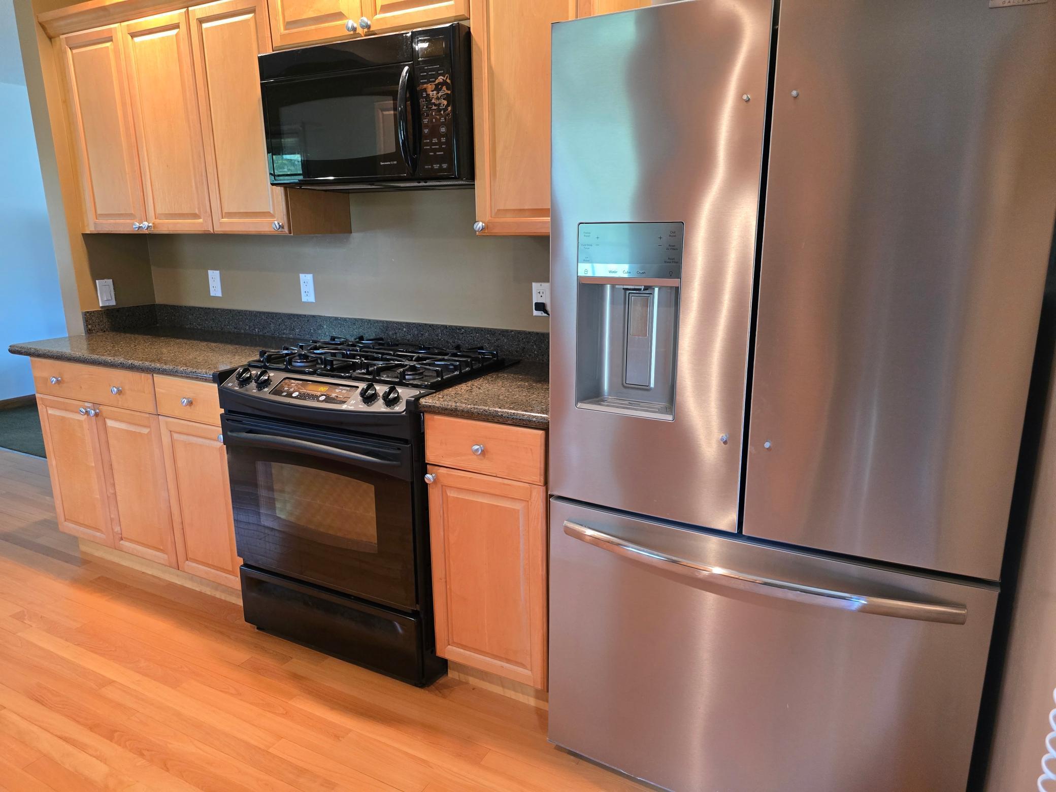 Newer stainless steel refrigerator with convenient ice and water dispenser on the door.