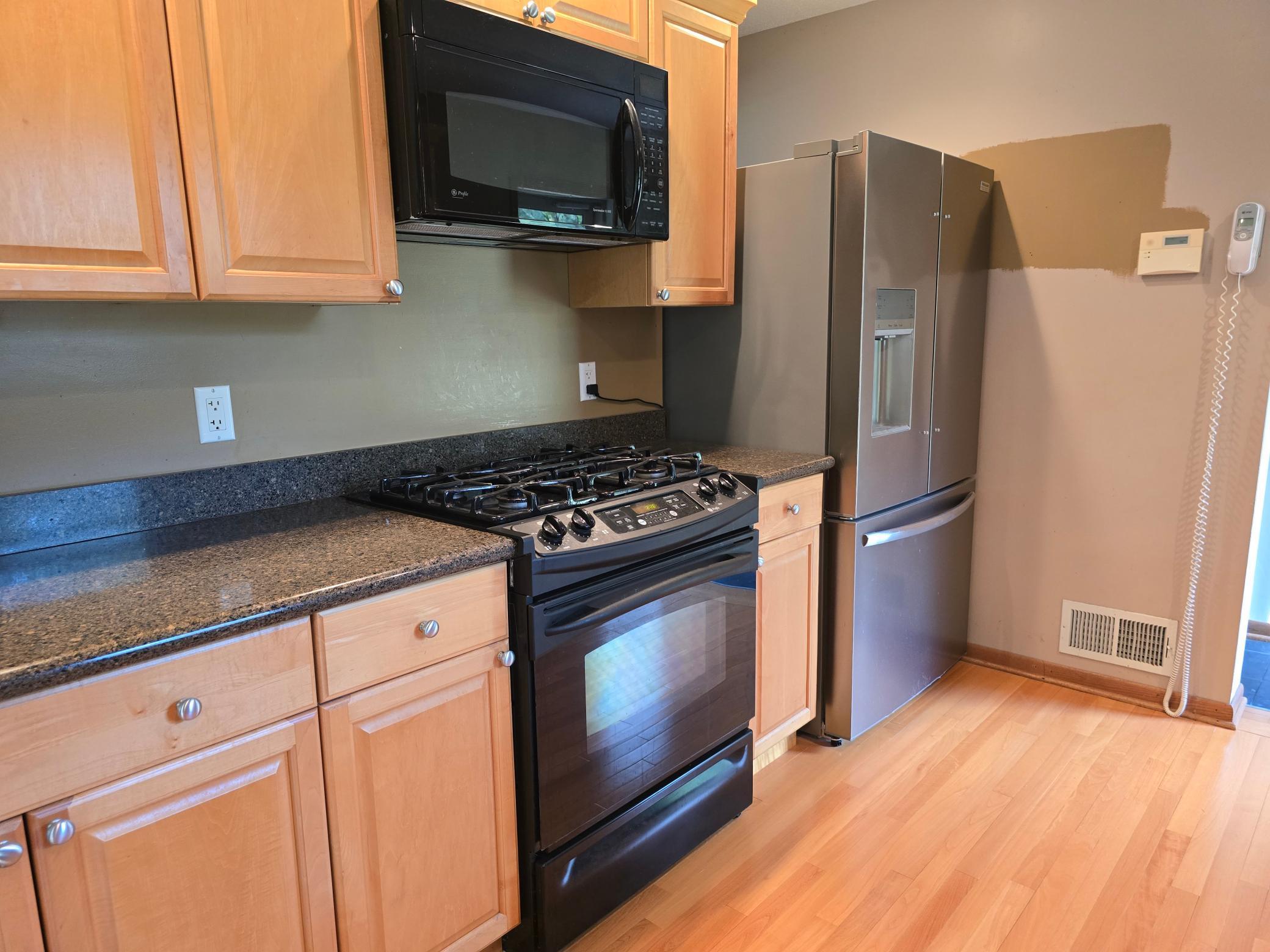 Beautifully updated kitchen with Corian countertops, refreshed cabinetry, and newer flooring.