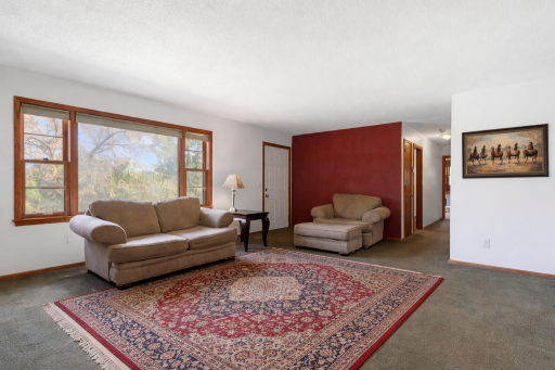 Spacious living room featuring oversized windows that flood the space with natural sunlight. Virtually staged.