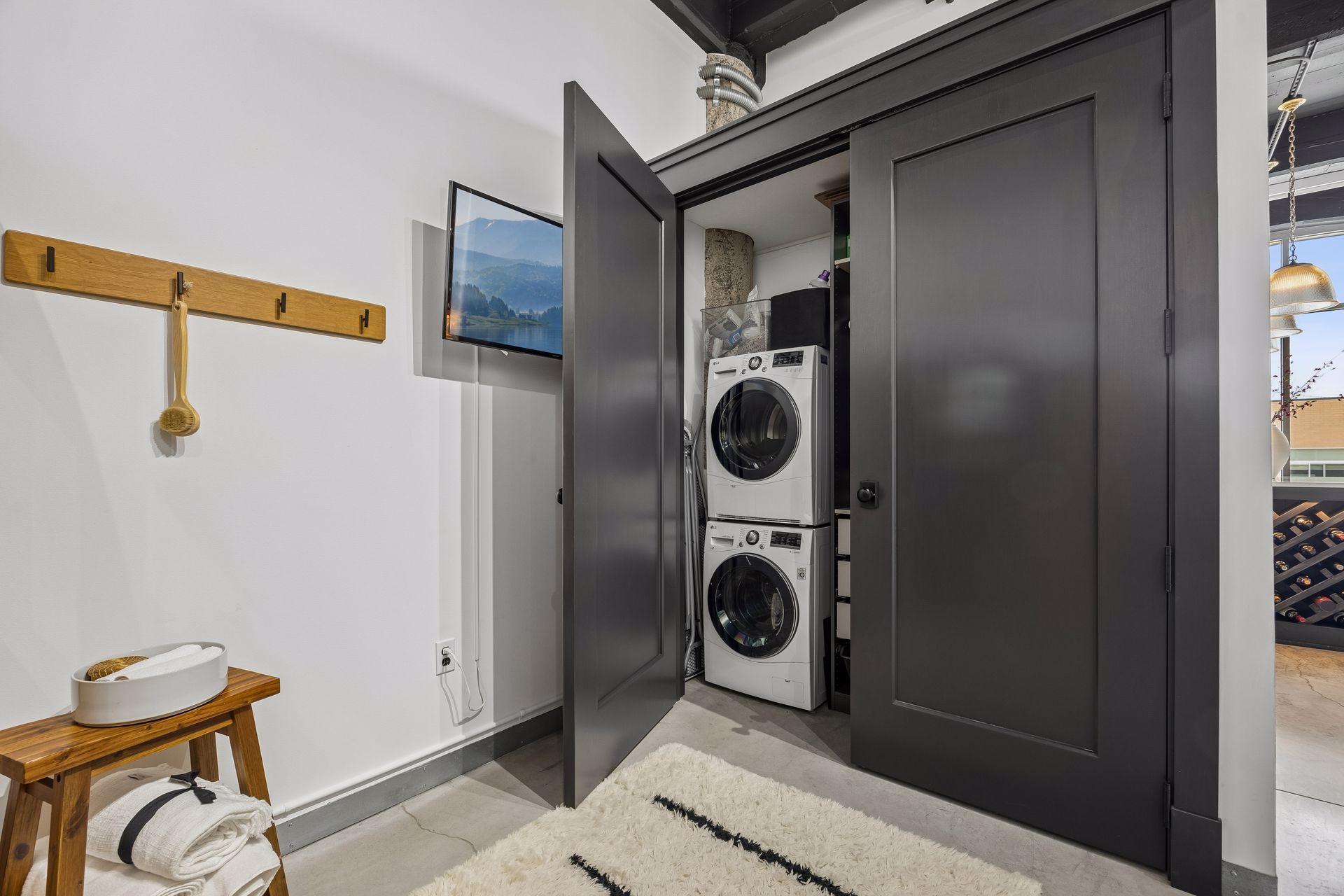 A custom cabinet with French doors in this space conceals a washer and dryer with added storage, blending utility with elegance.
