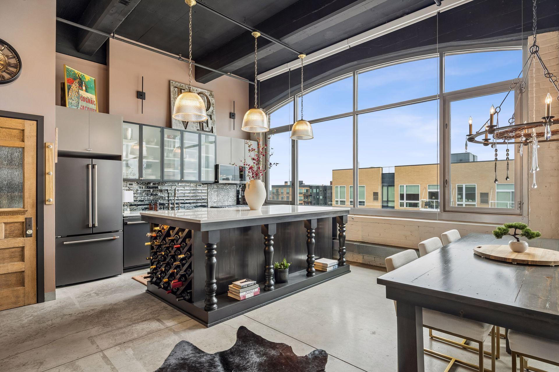 Angled view into the kitchen, where the bespoke island anchors the space beneath expansive windows that fill the room with natural light.