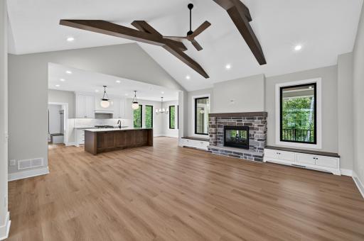 Architectural beams, a stone fireplace, and an open floor plan create an impressive space for entertaining and everyday living.