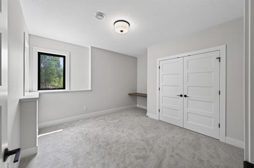 A light-filled bedroom offering tranquil views, plush carpeting, and a dedicated workspace for today's lifestyle.