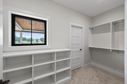 Luxury walk-in closet with custom shelving, abundant storage, and a window that fills the space with natural light.