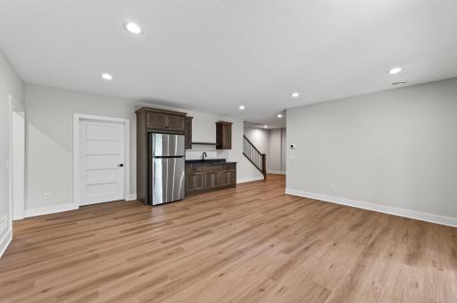 A spacious lower-level retreat with luxury flooring, a wet bar, and endless possibilities for entertaining.