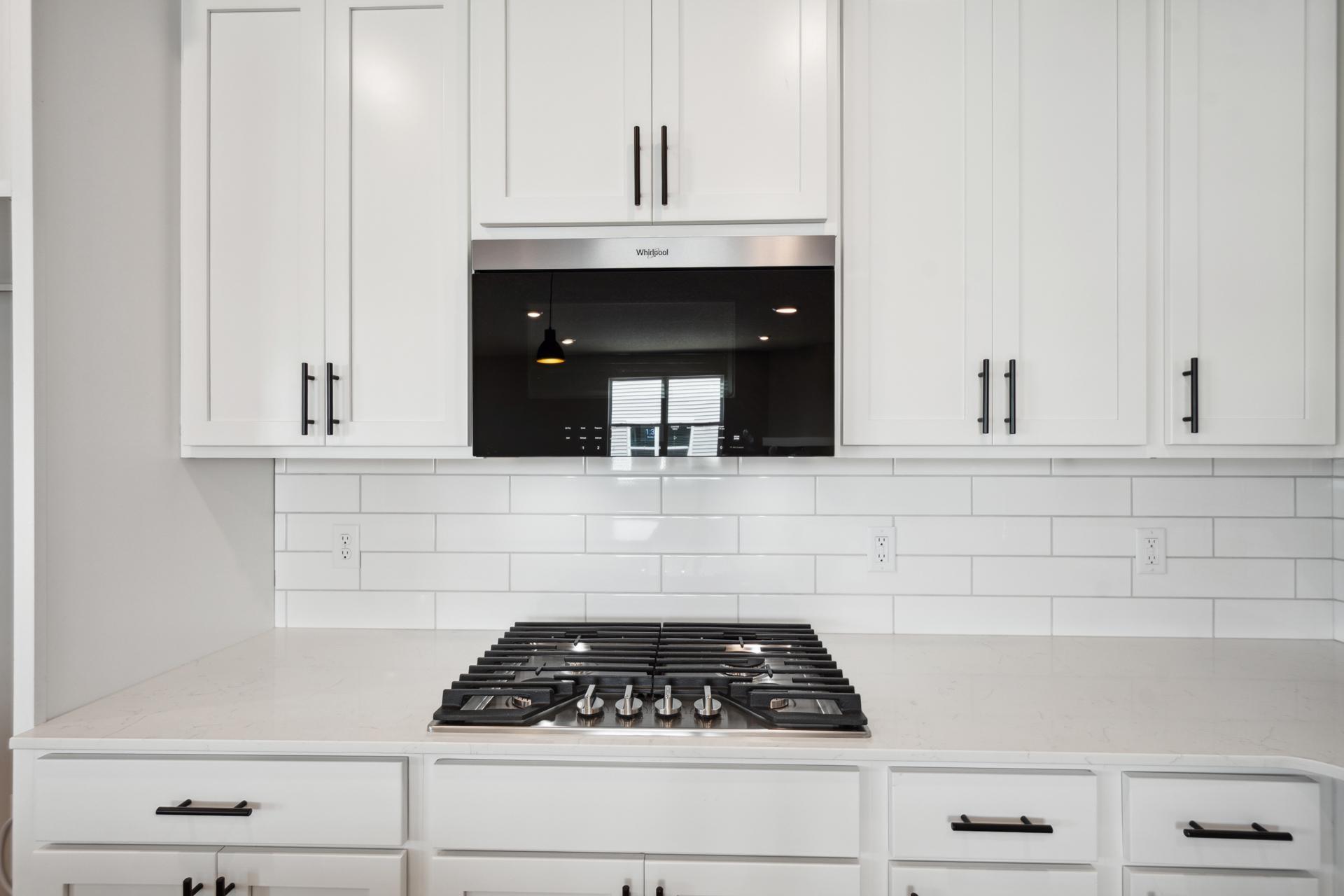 Gas cooktop and microwave with air fryer that vents to exterior.