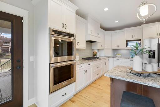 dual oven, gas range, tile backsplash, under cabinet lights
