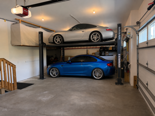 Oversized 3 car garage with hi ceilings. Car lift is an example using AI